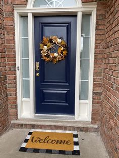 a blue front door with a welcome mat