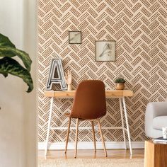 a chair and desk in front of a wallpapered wall with geometric designs on it