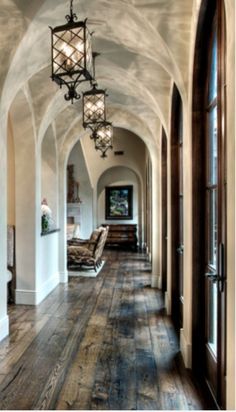 a long hallway with wooden floors and chandelier