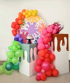 the balloon arch has been decorated with colorful balloons and streamers to make it look like they are dripping