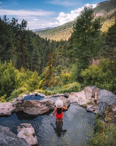 a person standing in a pool of water surrounded by rocks