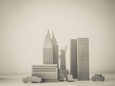 a black and white photo of skyscrapers in the distance with one person standing on top