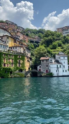 some buildings on the side of a hill next to water