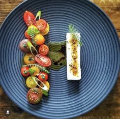 a blue plate topped with lots of different types of food on top of a wooden table