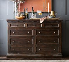 a dresser with wine bottles and glasses on it