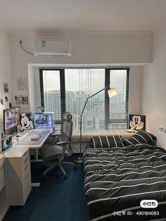 a bed room with a neatly made bed and a computer desk in front of a window