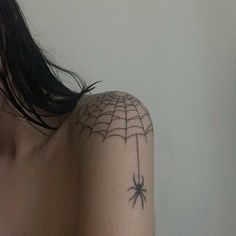 a woman with a spider web tattoo on her shoulder