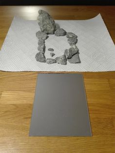 a table with rocks on it and a towel next to the mat that has been made