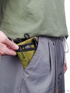 a person is holding their pocket open to show the inside of his pants and belt