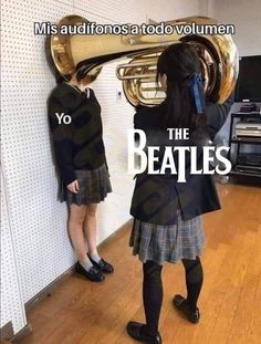 a girl in a school uniform is playing the trumpet while another girl stands behind her