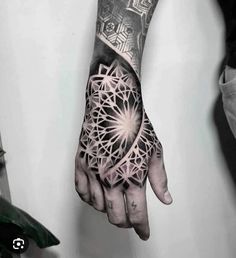 a man's hand with an intricate tattoo on it