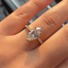 a woman's hand with a diamond ring on it