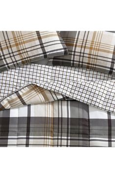 three plaid sheets are folded up on top of each other, one is brown and white