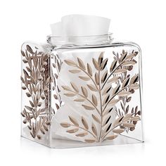 a glass tissue dispenser with leaves on it