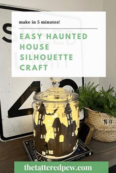 a mason jar with the words easy painted house silhouette craft on it next to a potted plant