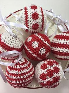 four red and white crocheted ornaments on a plate