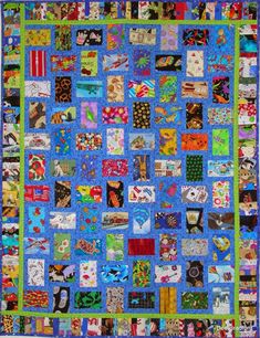 a blue quilt with lots of different pictures and words on the front, along with green trim