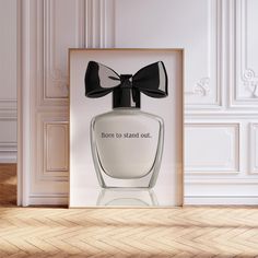 a bottle of perfume with a bow on it sitting in front of a framed photograph