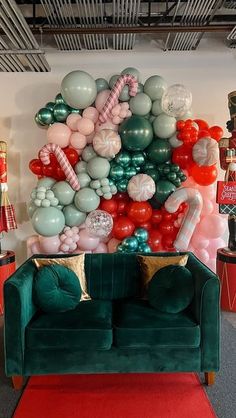 a green couch sitting in front of a balloon wall