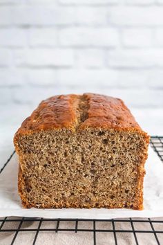 a loaf of banana bread sitting on top of a white plate next to a cooling rack