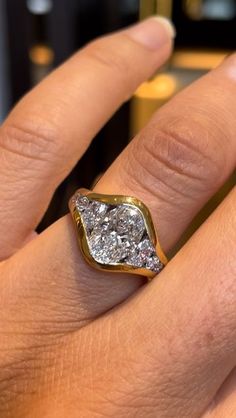 a woman's hand with a gold and white diamond ring on her left finger