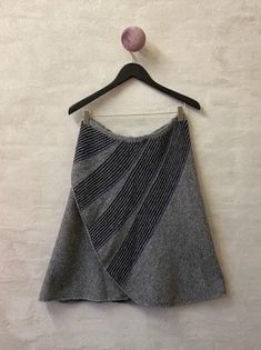 a gray skirt hanging on a wall