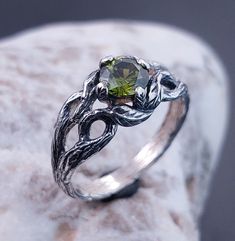 Unique Emerald Stone Elven Style Engagement Ring with Leaves on Branches, Celtic Style Wood Texture Ring, Perfect Gift for Her This is a nature lover's dream. A unique engagement ring created by nature itself, a Silver Branch with great texture and graceful leaves that wrap around your finger, with an Emerald sparkling between them. DETAILS: Stone - 6mm  Metal - recycled solid Sterling Silver Finish - oxidized View all silver branch rings: https://www.etsy.com/shop/TinyShinyJewel?ref=seller-platform-mcnav&section_id=43346778 Care instructions: To care for the ring, avoid contact with water and chemicals such as perfumes and lotions. When the ring is not in use, store it in a dry, cool place to prevent tarnishing. Additional information:  ✦ All rings are made to order. An average turnaround Fantasy Silver Rings For Anniversary, Fantasy Style Silver Ring For Anniversary, Silver Fantasy Rings For Anniversary, Silver Peridot Solitaire Ring, Silver Peridot Jewelry With Center Stone, Fantasy Sterling Silver Jewelry For Anniversary, Engagement Ring With Leaves, Ring With Leaves, Elven Style