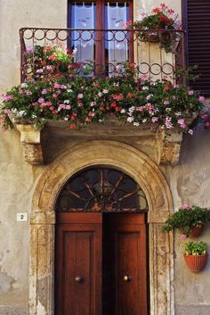 an old building with flowers on the balcony