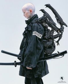 a man with white hair wearing a black jacket and holding two large metal objects in his hands