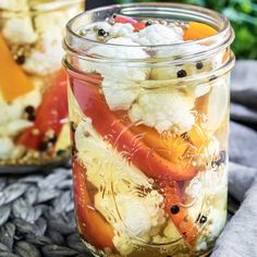 two jars filled with food sitting on top of a table next to eachother