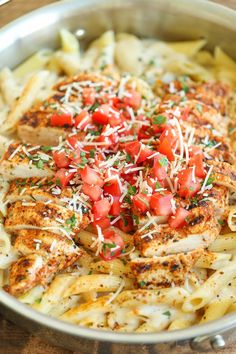 chicken pasta with tomatoes and parmesan cheese in a pan