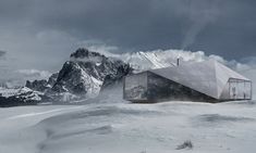 a building on top of a snow covered hill with mountains in the backgroud