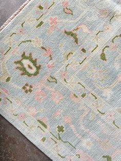 a blue rug with pink and green flowers on it