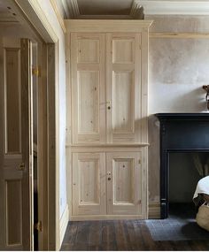 an empty room with a fireplace and large wooden doors on the wall next to it