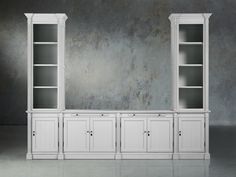 an empty white bookcase with two doors and three cupboards in front of a concrete wall