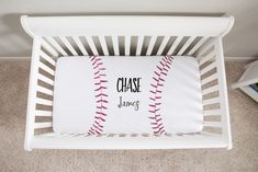 a white crib with a baseball pillow on it and the words chase james written in black