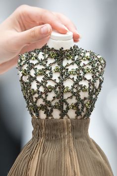 a person holding onto a dress with beading on it