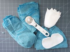 a pair of scissors sitting on top of a blue towel next to a white flower