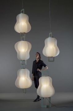 a woman is standing in front of some lamps