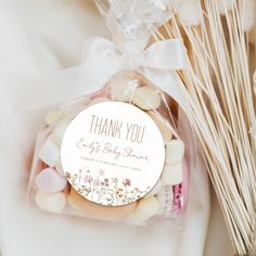 a thank you gift bag filled with cookies and marshmallows next to some dried grass