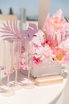 pink flowers and wine glasses on a table