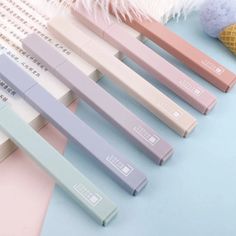 four pastel colored pencils sitting next to each other on top of a table