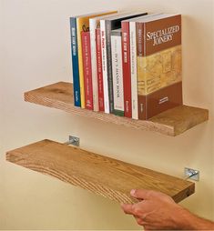 two shelves with books on them and a hand reaching for the book to be opened