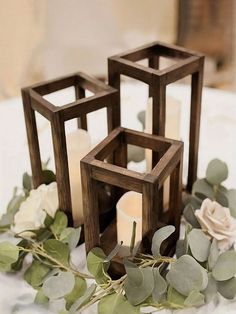 two wooden cubes with candles and greenery