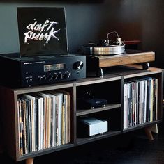 an old record player sitting on top of a wooden shelf