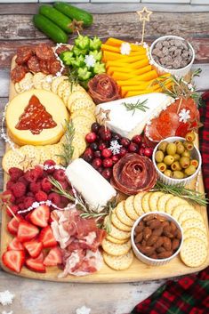 a wooden platter filled with cheese, crackers, fruit and meats on top of snow flakes