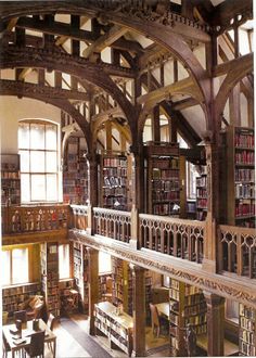 an old library with many bookshelves and tables