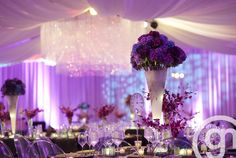 the centerpieces on this table are filled with purple flowers