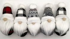 four knitted gnomes with white hair and beards are lined up in a row