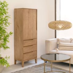 a living room with a white couch and wooden cabinet next to a potted plant